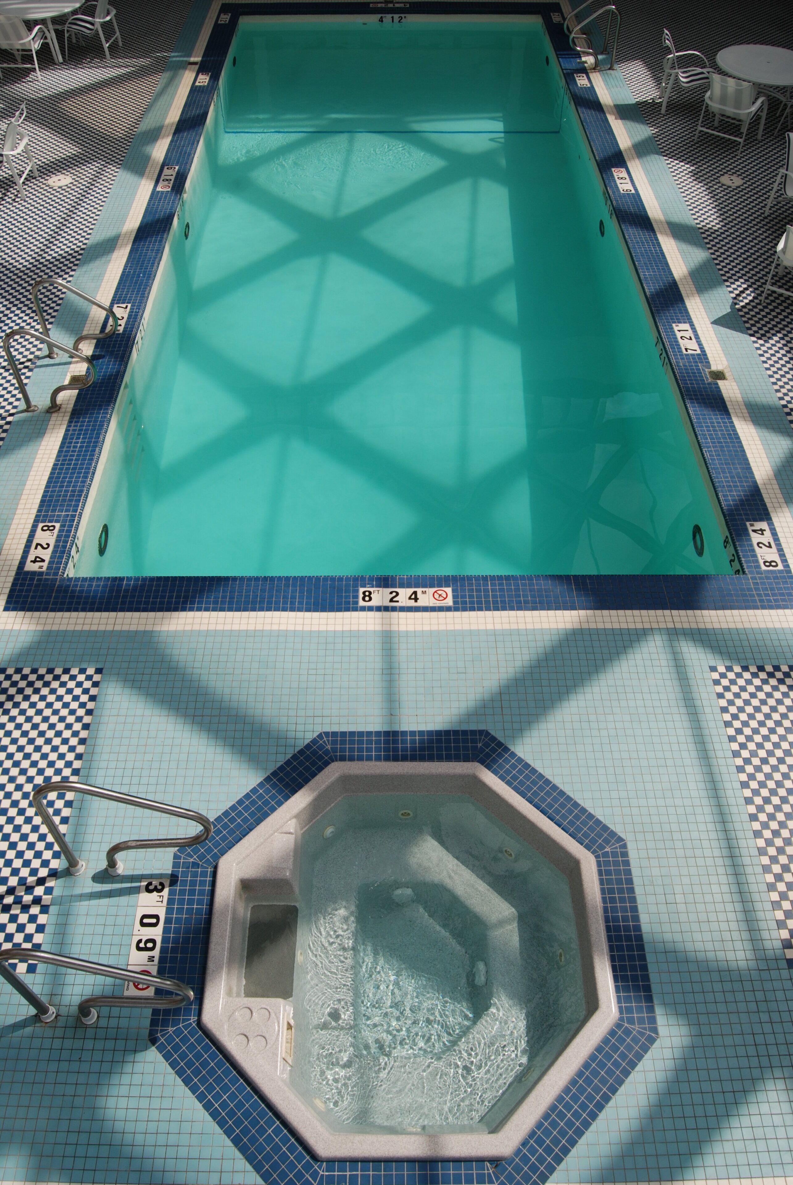 Una piscina con trampolín y zona de hidromasaje.