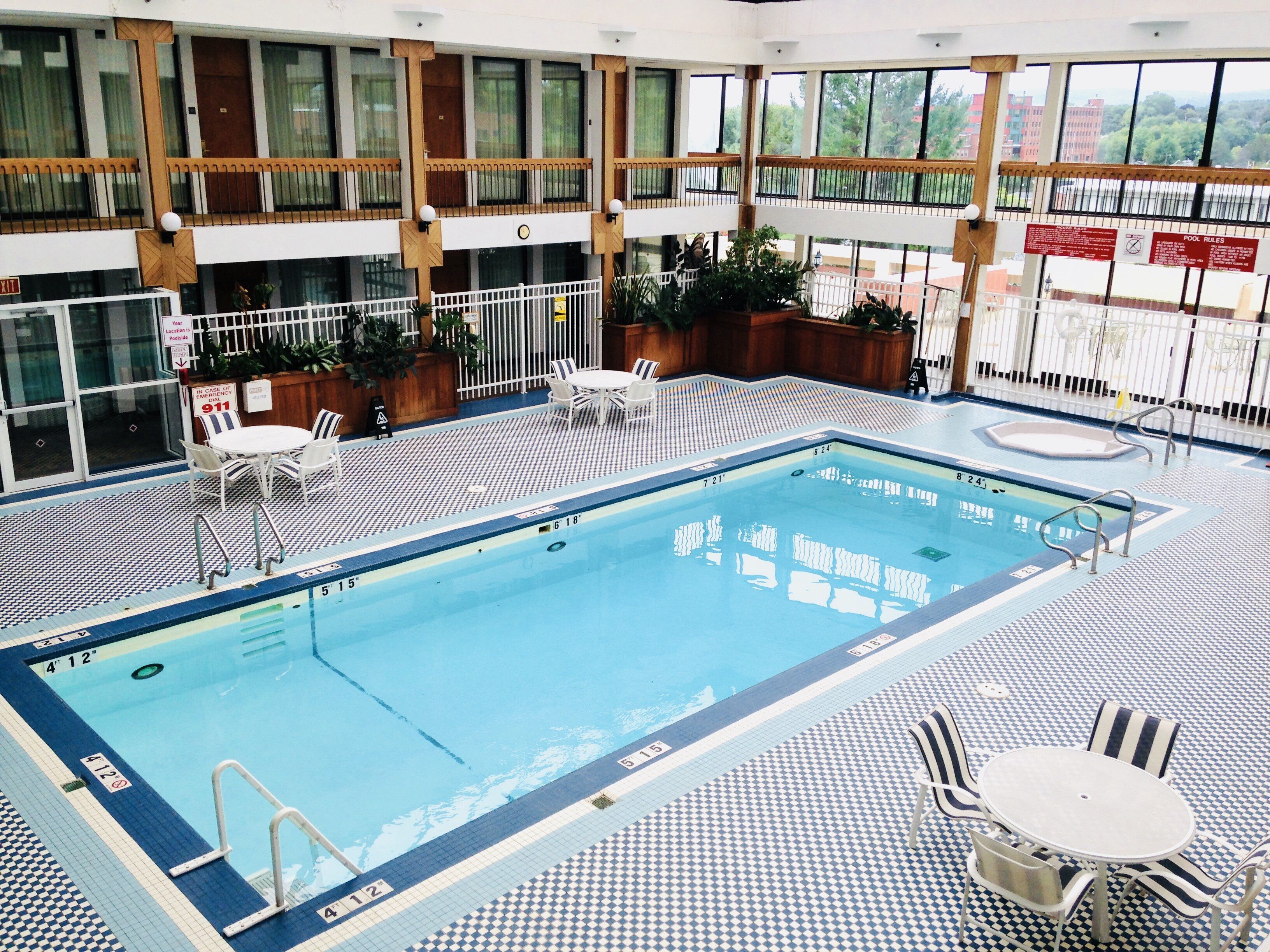 Una piscina interior con varias pistas de natación, zonas de estar y barandillas de seguridad.