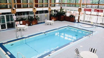Una piscina interior con varias pistas de natación, zonas de estar y barandillas de seguridad.