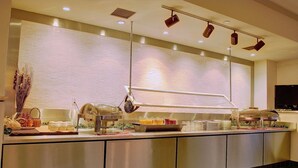 A buffet area with a counter, food items, and a beverage station. - Holiday Inn & Suites Pittsfield-Berkshires by IHG (Pittsfield)