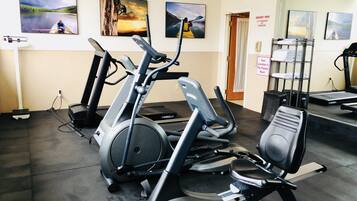 A gym with stationary bikes, treadmills, and a weight bench.