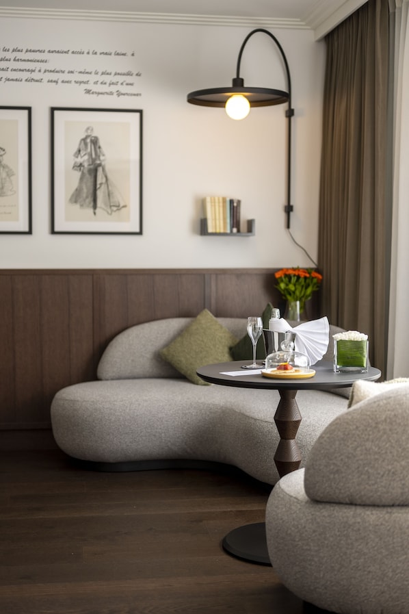 A cozy seating area with a cushioned bench, a small round table with a glass dome, and a wall-mounted lamp.