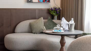 Una sala de estar moderna con un sofá, una mesa redonda con una lámpara y una estantería con libros y un cuadro enmarcado.