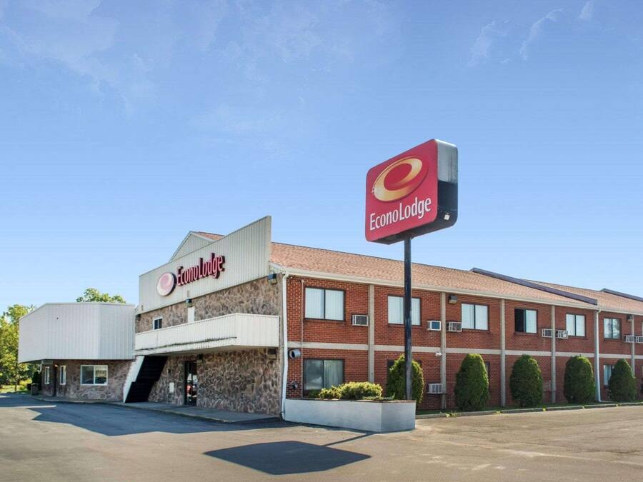 Un edificio de EconoLodge de dos pisos con fachada de piedra y techo plano.