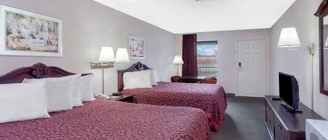 Habitación de hotel con dos camas, un escritorio, televisión y microondas.