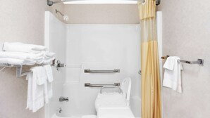 A modern bathroom with a bathtub, shower, and toilet. There are towels on a rack and a shower curtain. - Days Inn by Wyndham Morristown (Morristown)