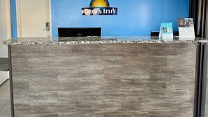 A reception desk with a blue wall, a sign reading "Days Inn", and a security camera above the door. - Days Inn by Wyndham Morristown (Morristown)