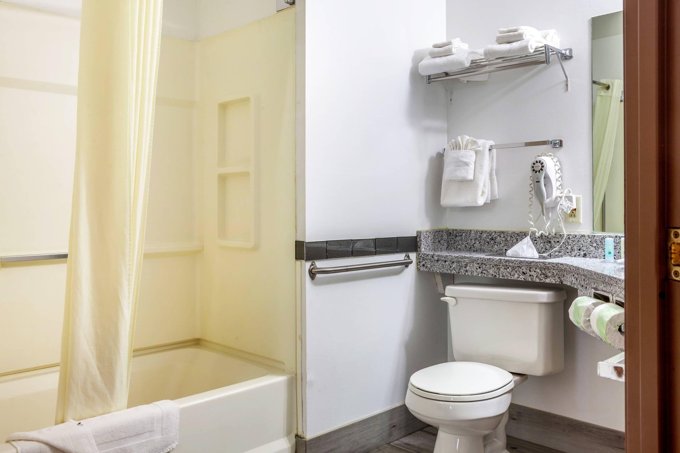 Un baño con bañera, inodoro y cortina de ducha.