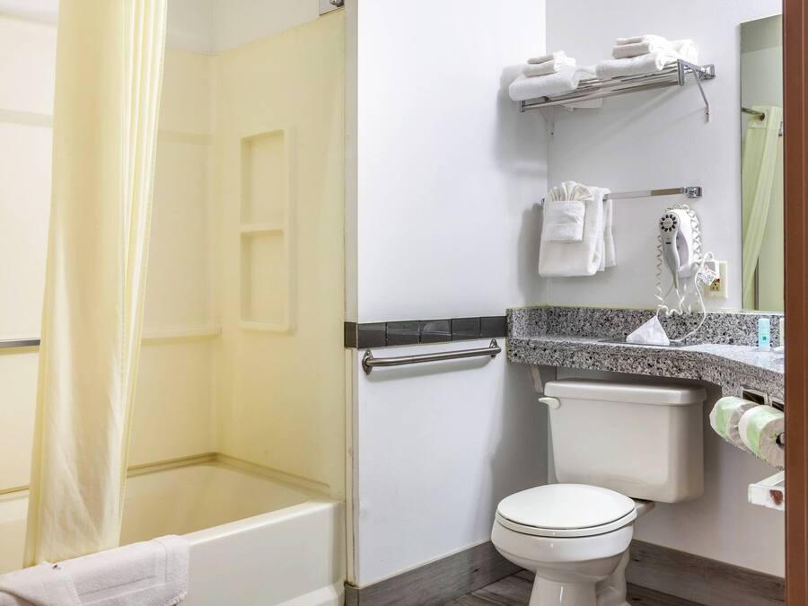 Un baño con bañera, inodoro y cortina de ducha.
