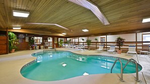 An indoor swimming pool with a wooden ceiling, lounge chairs, and potted plants. - Quality Inn & Suites Prairie Du Chien (Prairie Du Chien)