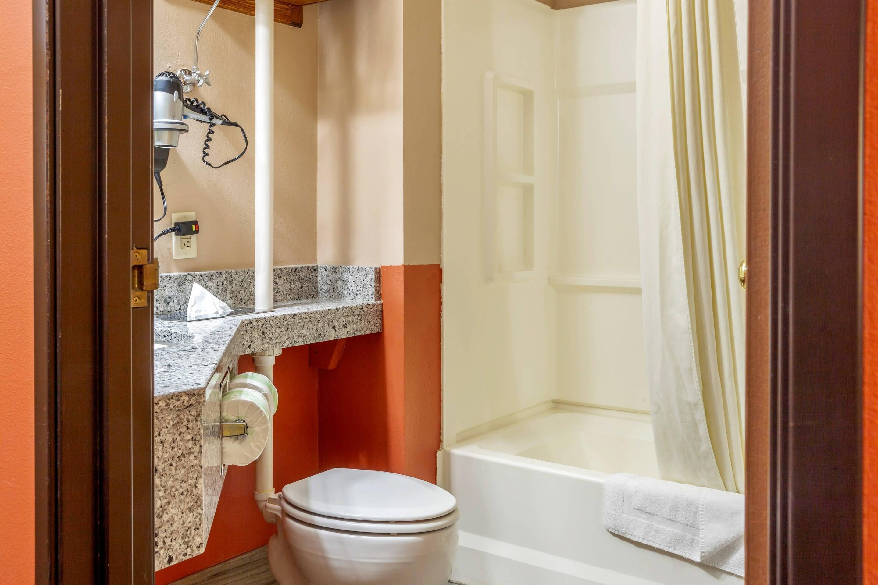 A bathroom with a toilet, sink, and bathtub.
