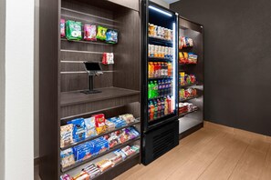 A self-service beverage vending machine with various drink options and snacks. - Wingate by Wyndham Oshkosh (Oshkosh)