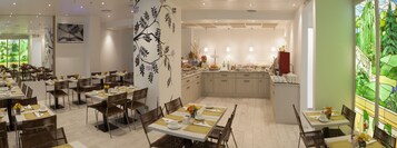 Un ristorante con diversi tavoli, sedie e una cucina centrale.