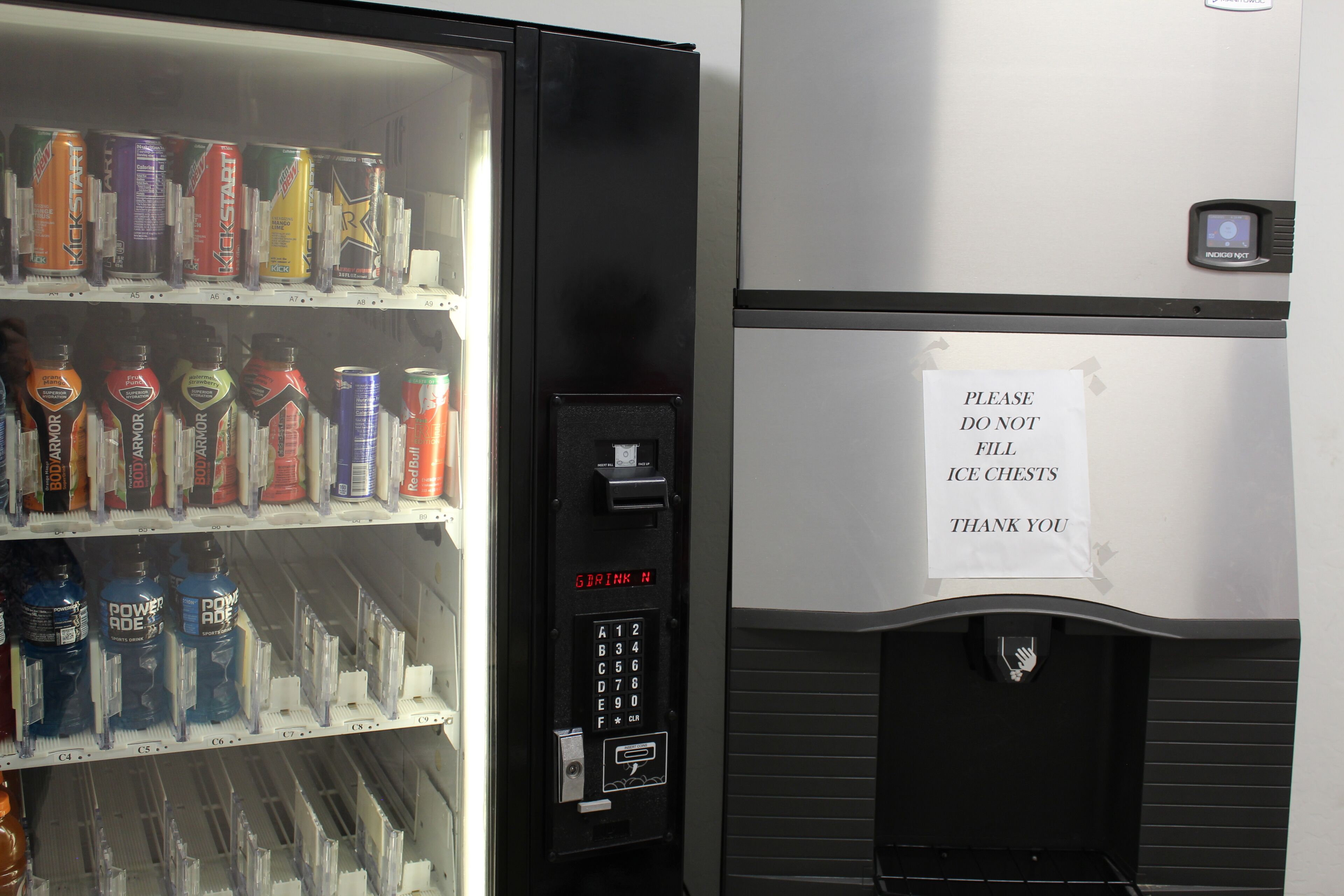 Een automaat met diverse drankjes en een bordje met de tekst: geen ijskisten vullen.