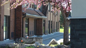 A building with a brick facade, large windows, and a stone pathway leading to the entrance.