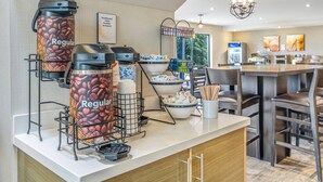 A coffee station with multiple coffee dispensers, bowls of sugar, and a coffee machine.