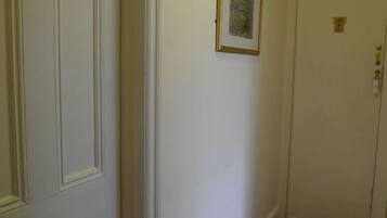 A hallway with white doors numbered 207 and 208, a framed picture on the wall, and a brown carpet.