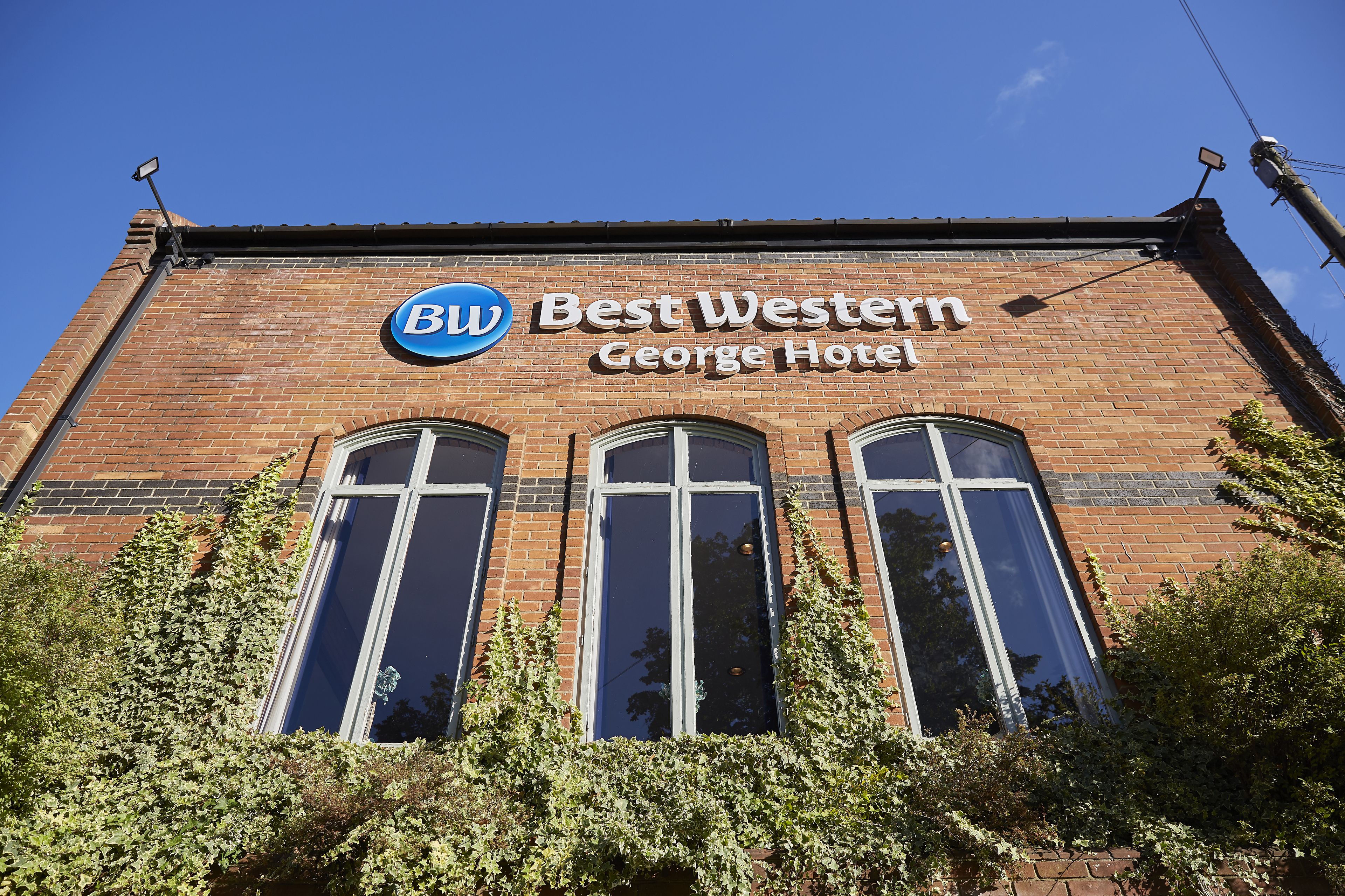 A brick building with a sign that reads "Best Western George Hotel."