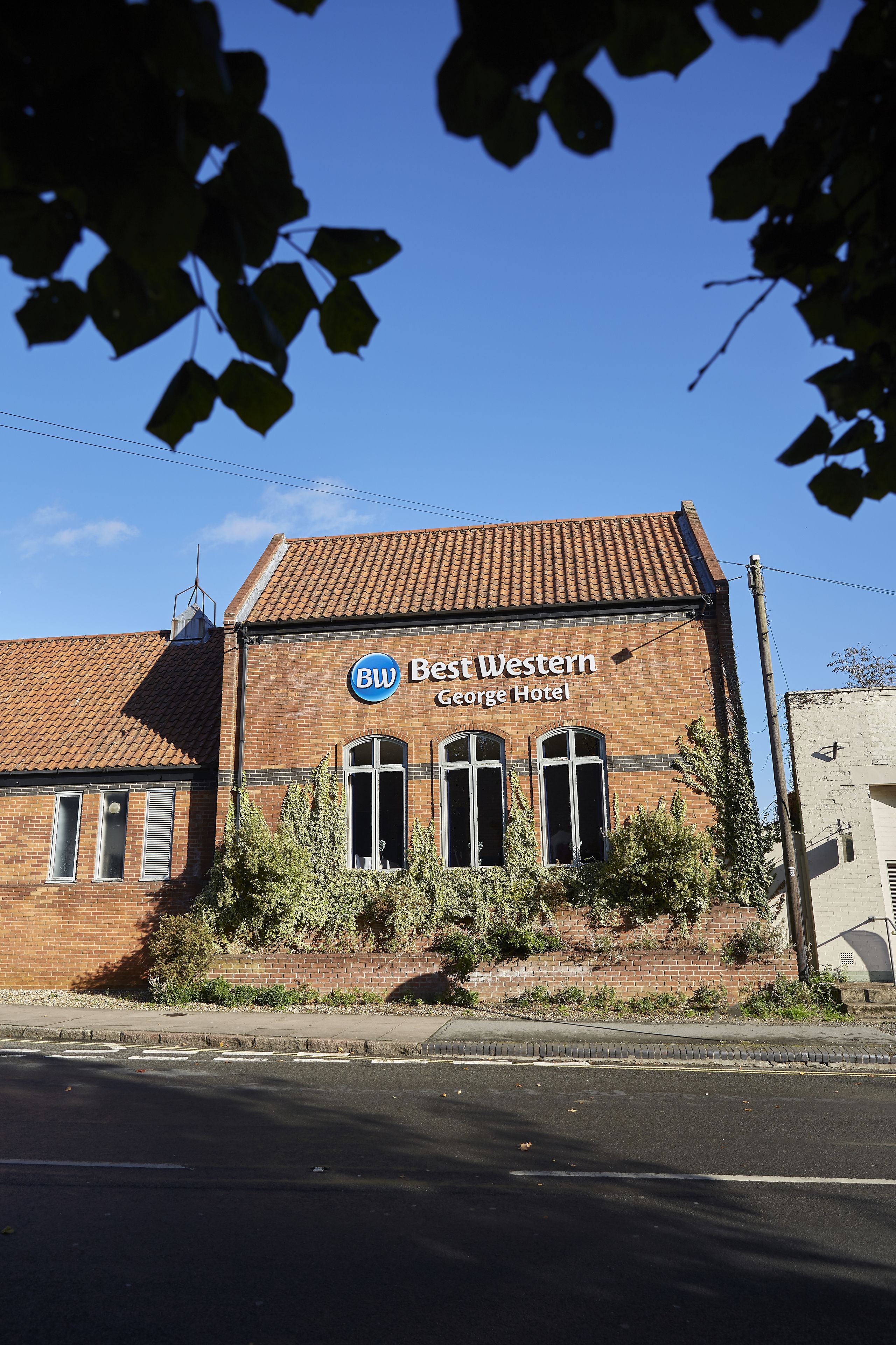 A two-story brick building with a sign reading "BW Best Western George Hotel."