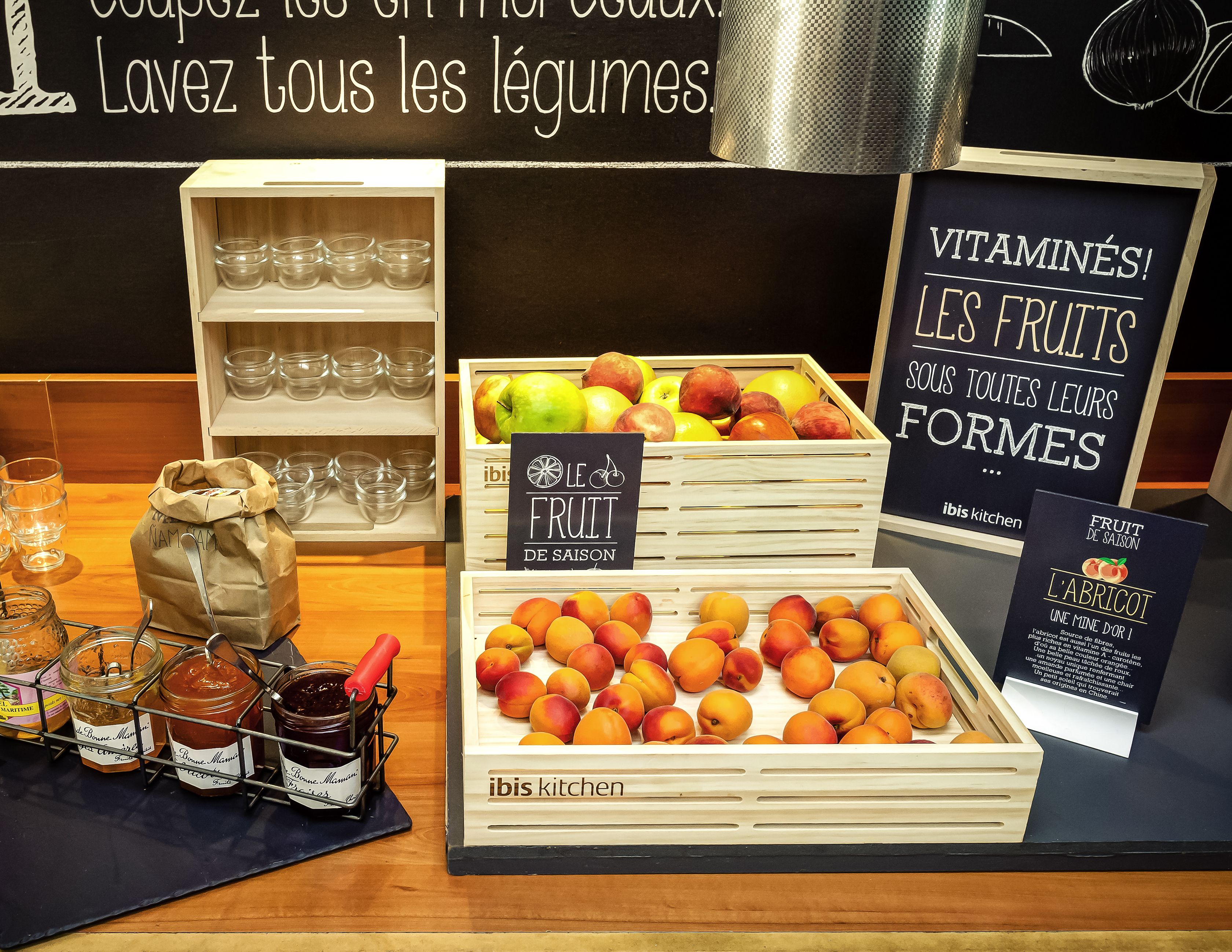 Exposição de frutas da época, potes de compotas e um letreiro que promove os benefícios da fruta para a saúde.