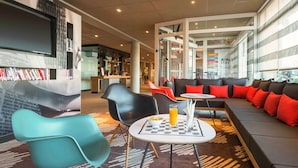 Un espace détente moderne comprenant des sièges, une table basse et une bibliothèque.
