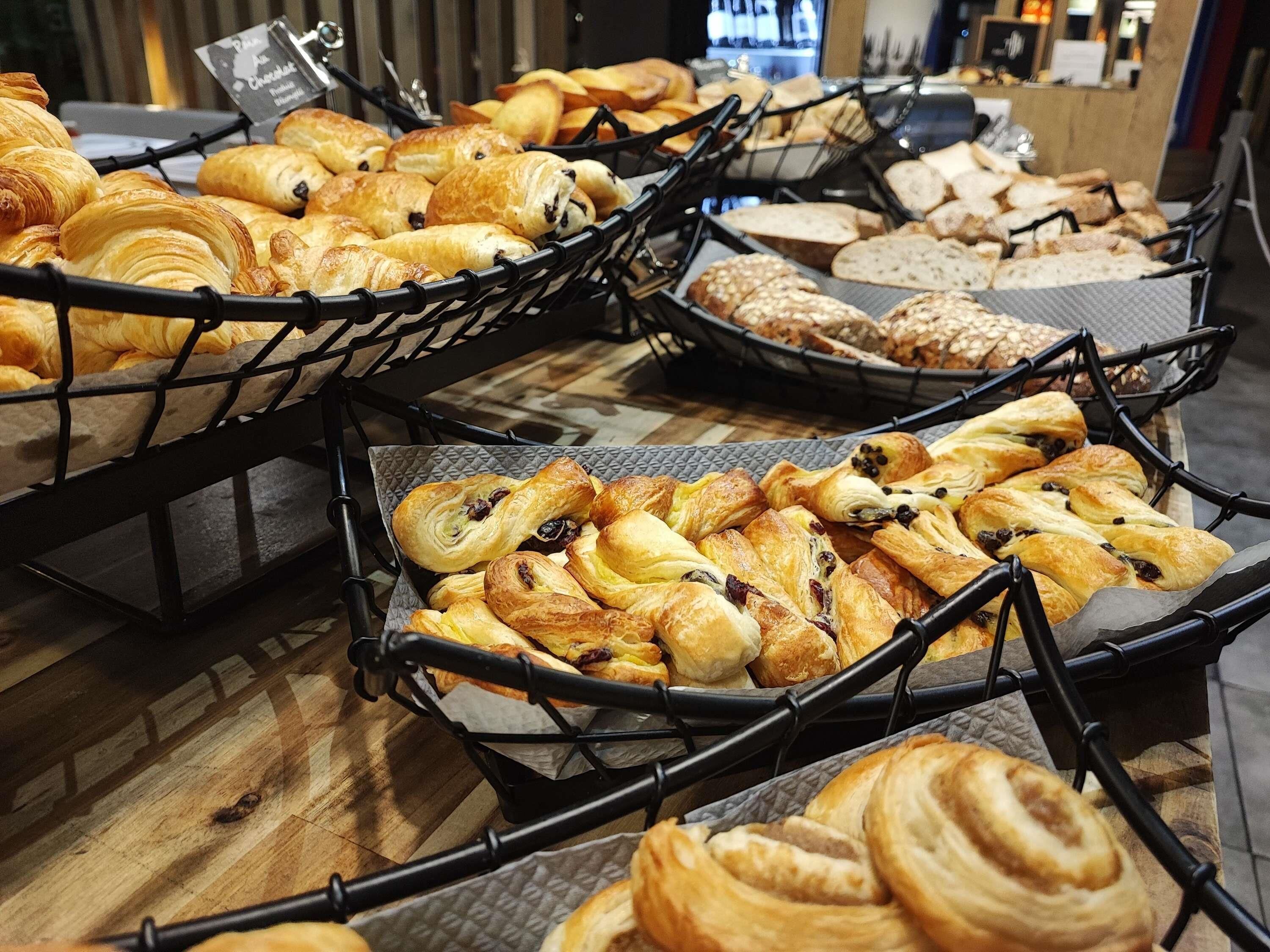 Une variété de pâtisseries présentées dans des paniers sur un plancher en bois.