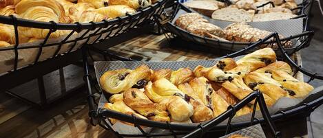 A variety of pastries displayed in baskets on a wooden floor.