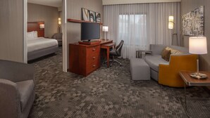 A hotel room with a bed, a desk, a chair, a sofa, and a TV. - Sonesta Select Newark Christiana Mall (Newark)