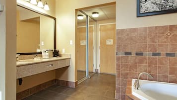 Un baño de hotel con lavabo, espejo y bañera.