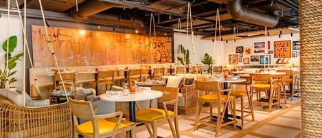 Un restaurant accueillant, doté de meubles en osier, de tables en bois et d’une ambiance chaleureuse et conviviale.