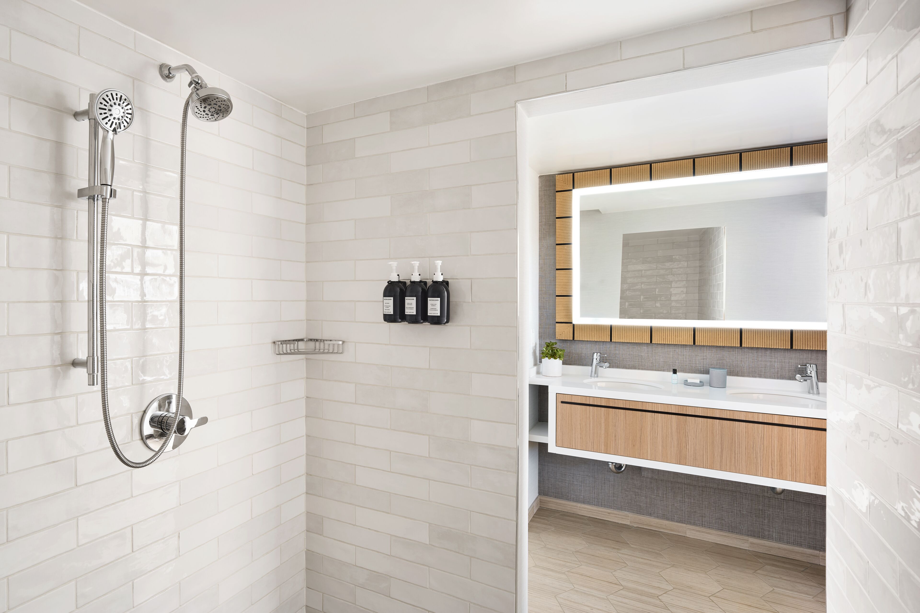 A modern bathroom with a shower, a large mirror, and a vanity with a sink.