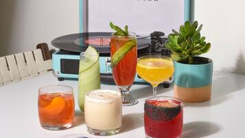 A table with various drinks, a record player, and a succulent plant.