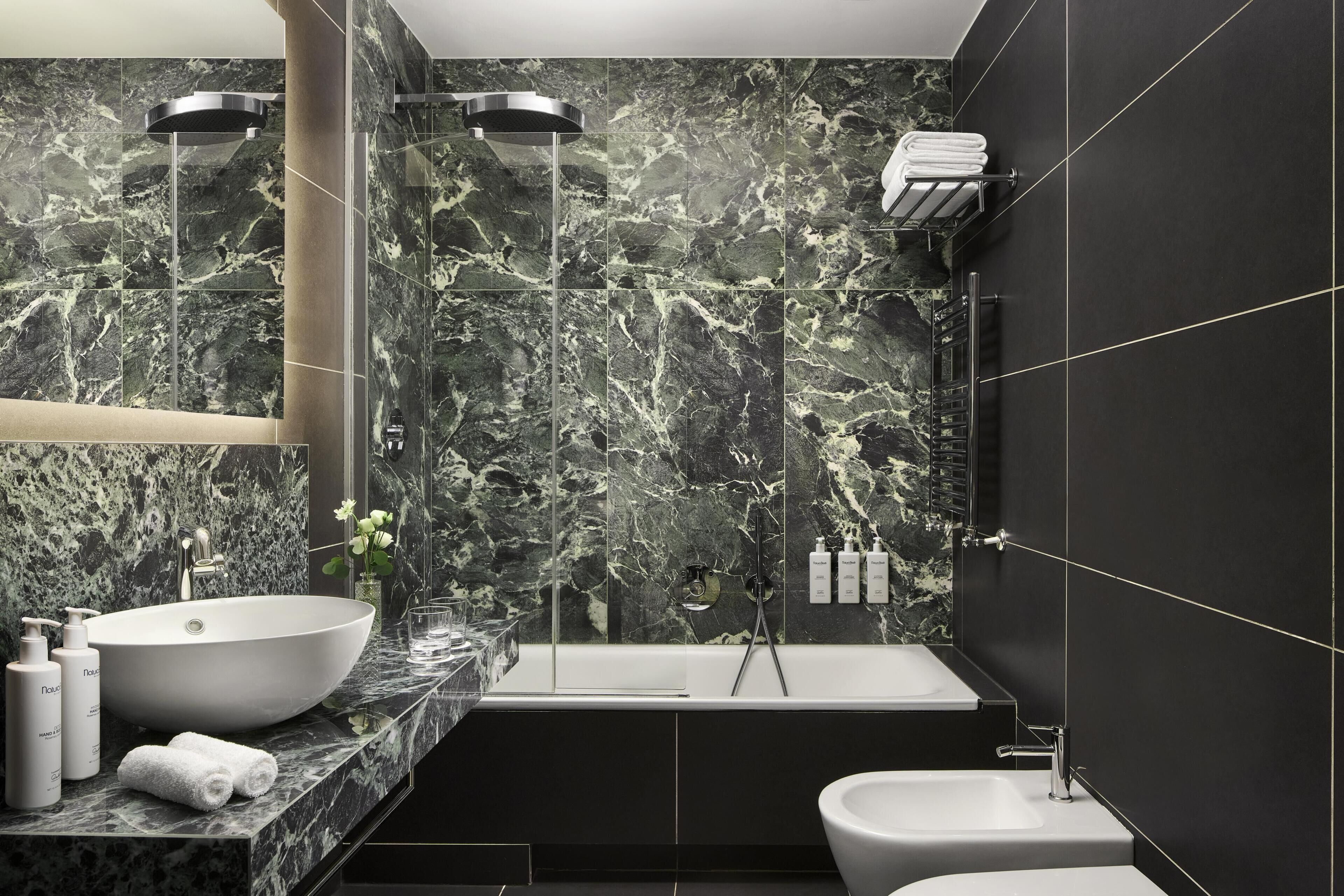 A modern bathroom with a large sink, a bathtub, and a toilet.