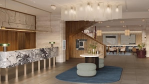 A modern lobby with a marble reception desk, a staircase, and a dining area with chairs and tables. - Tivoli President Milano Hotel (Milan)
