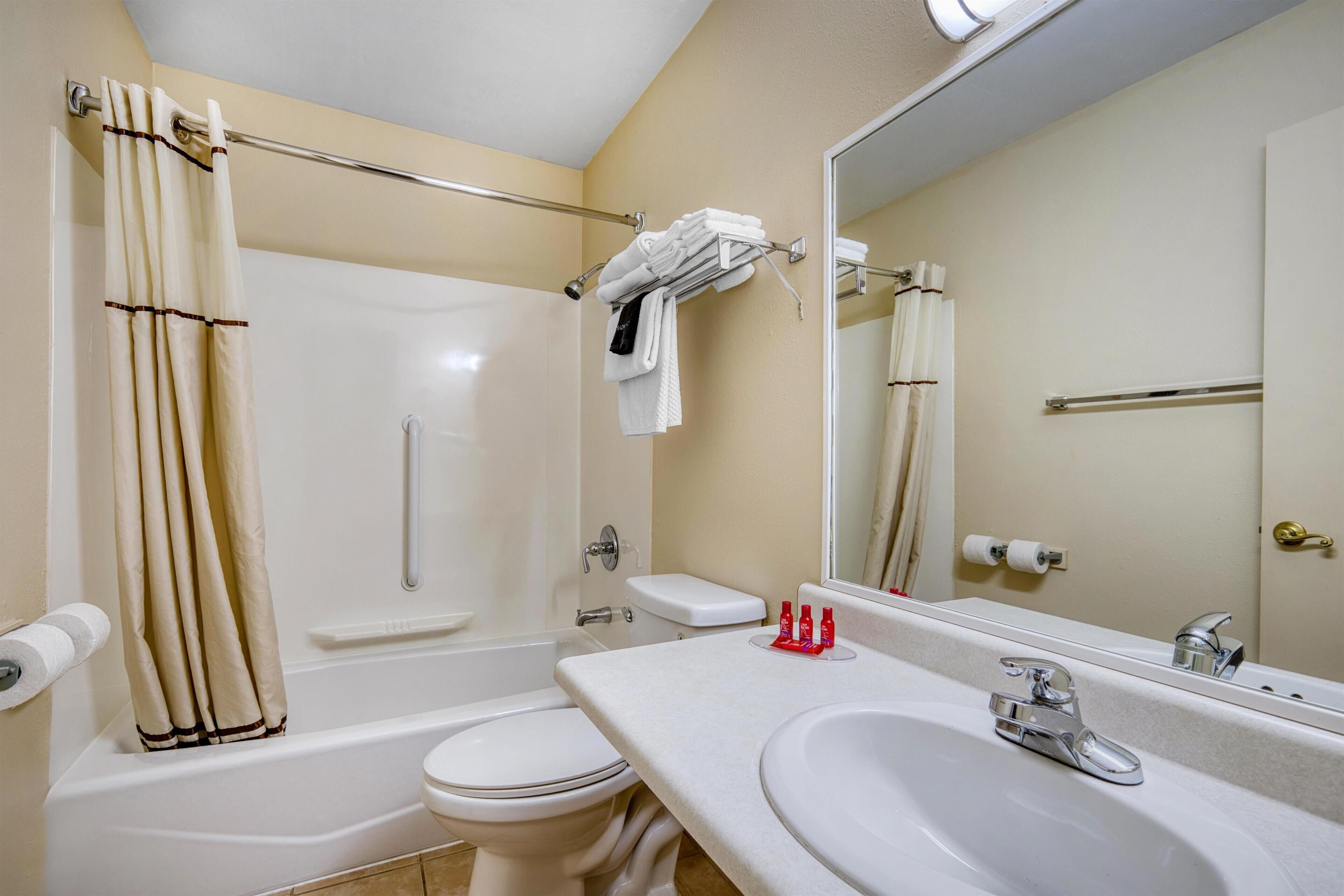Une salle de bain équipée d’une baignoire, de toilettes, d’un lavabo et d’un miroir.