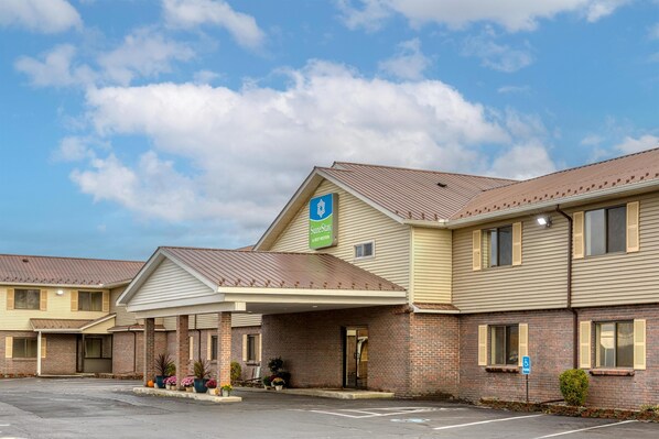 A hotel with a covered entrance, a sign indicating it is a SureStay hotel, and a parking lot. - SureStay by Best Western Massena (Massena)