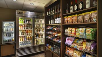 A convenience store with refrigerated beverage cases, snack aisles, and a selection of alcoholic beverages.