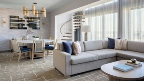 Un salon moderne avec une table à manger ronde, un canapé et un escalier en colimaçon.