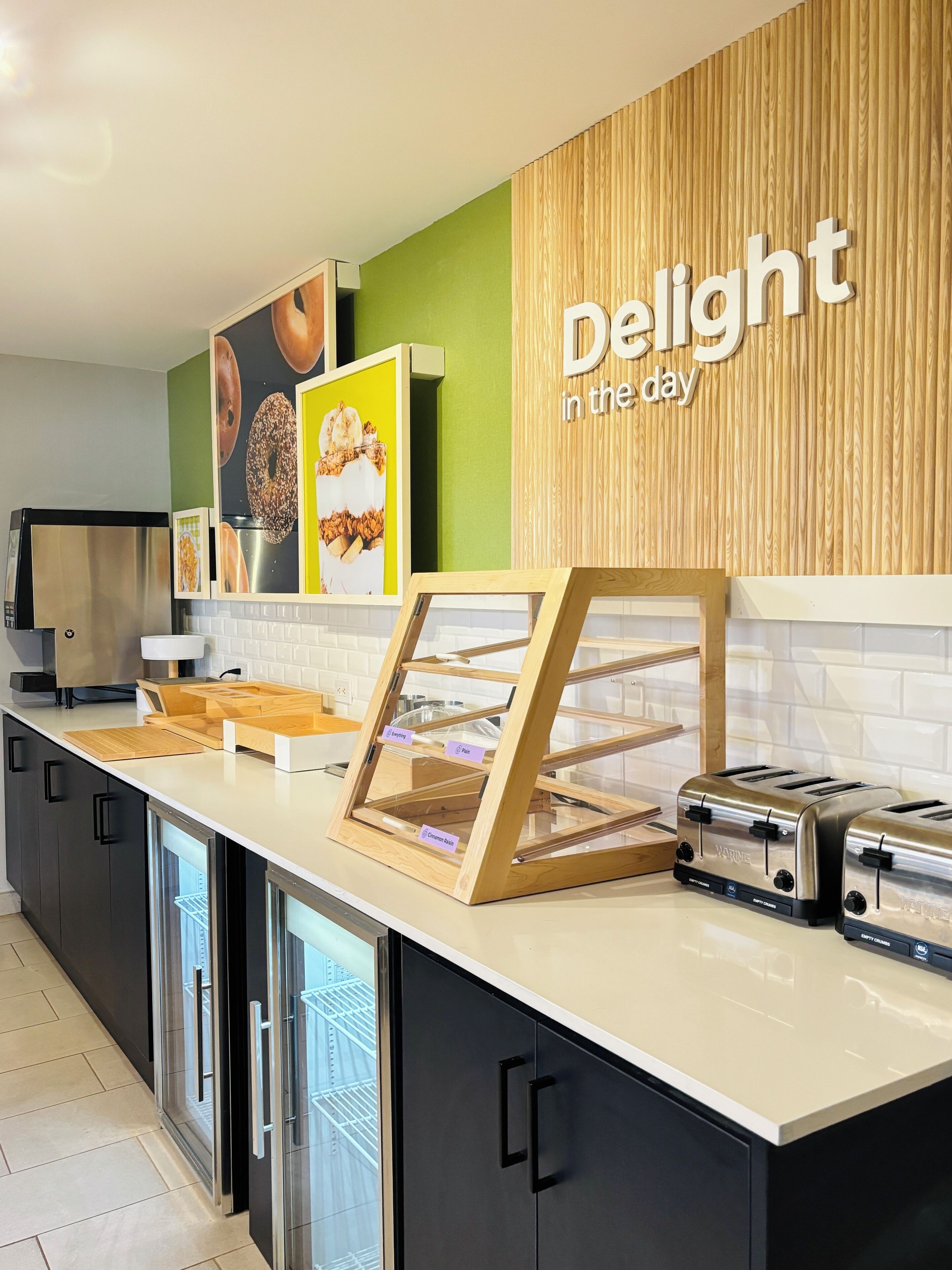 Une cuisine moderne avec un mur d’accent en bois, un présentoir pour produits de charcuterie et deux grille-pain.