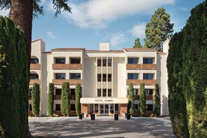 A modern hotel with a central entrance, multiple floors, and a symmetrical facade.