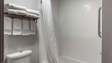 A bathroom with a toilet, a bathtub, and a shower curtain.