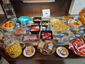 A buffet table with various food items including fruits, cheeses, meats, and pastries. - KYRIAD MONTLUCON - Saint Victor (Saint-Victor)