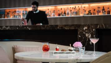 A bar area with a marble table, a martini glass, a dessert plate, and a cocktail glass.