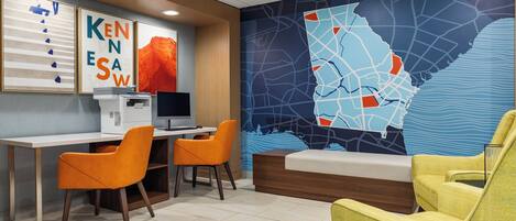 A modern office space with a desk, two chairs, a bed, and a large wall map.