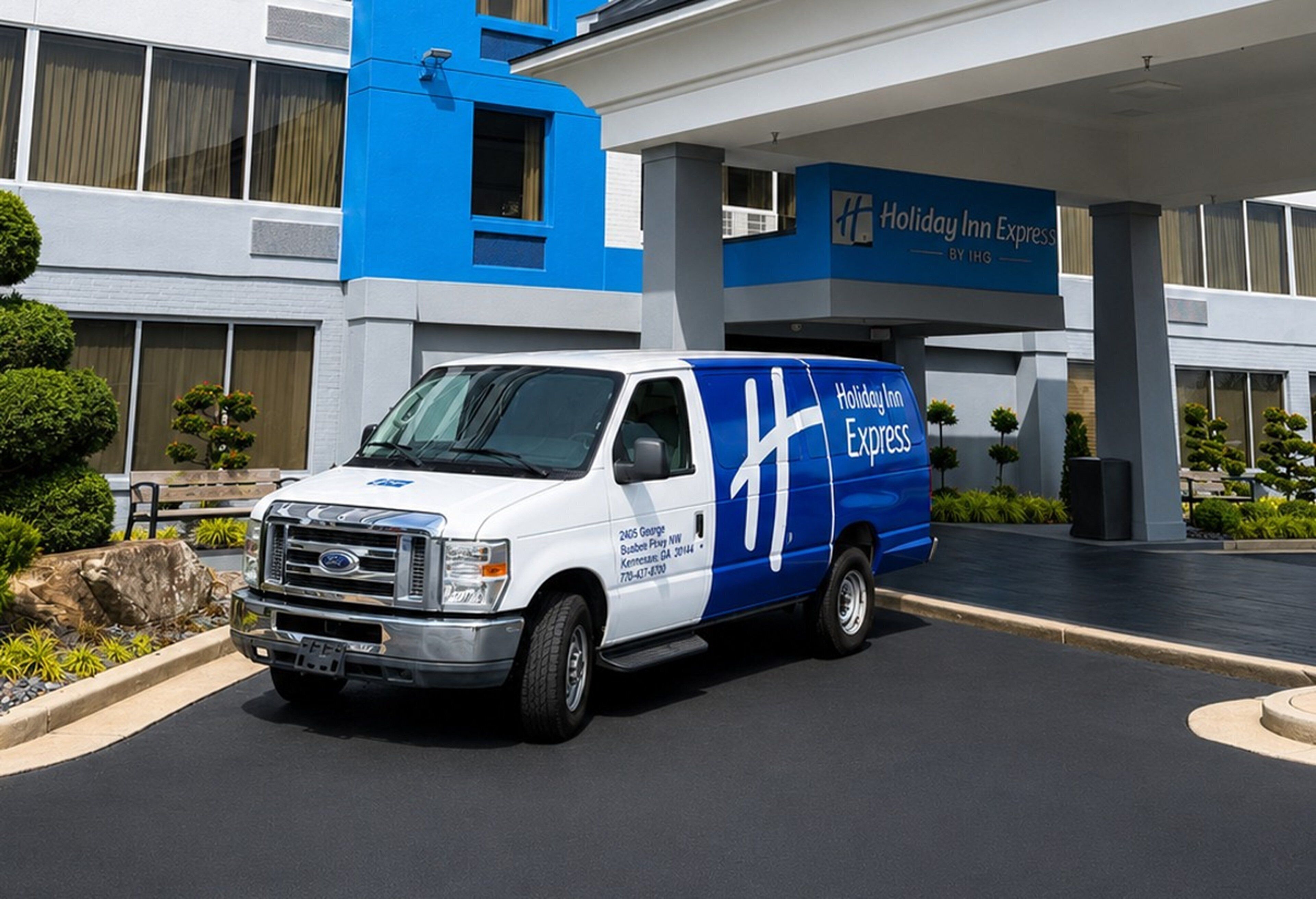 Entrada a un hotel Holiday Inn Express con un camión de reparto blanco y azul estacionado frente a él.