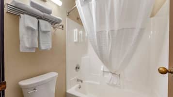 Une salle de bain équipée de toilettes, d’une baignoire et d’un rideau de douche.