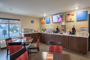 A breakfast area with seating, a coffee station, and a view of the outside. - Clarion Pointe Racine - Mount Pleasant (Mount Pleasant)