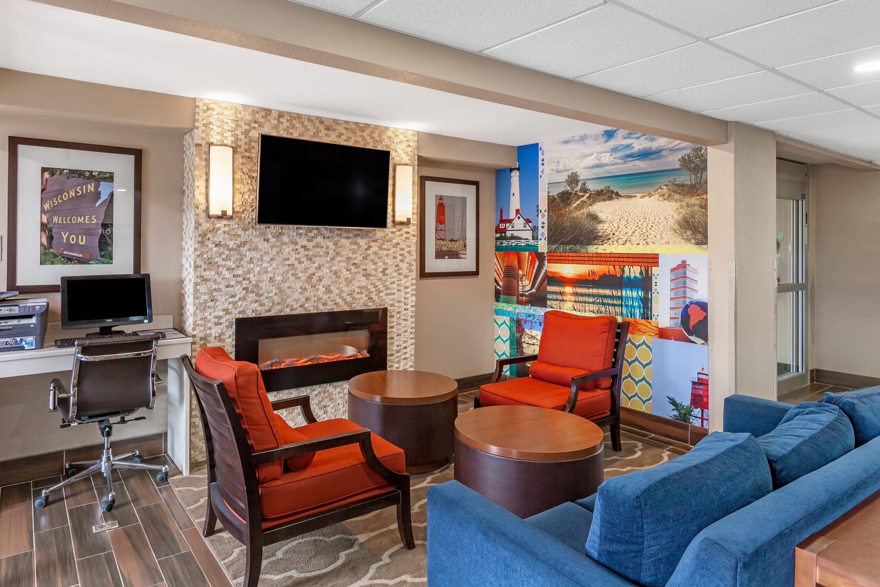 A hotel lobby with a fireplace, seating area, and a flat-screen TV.