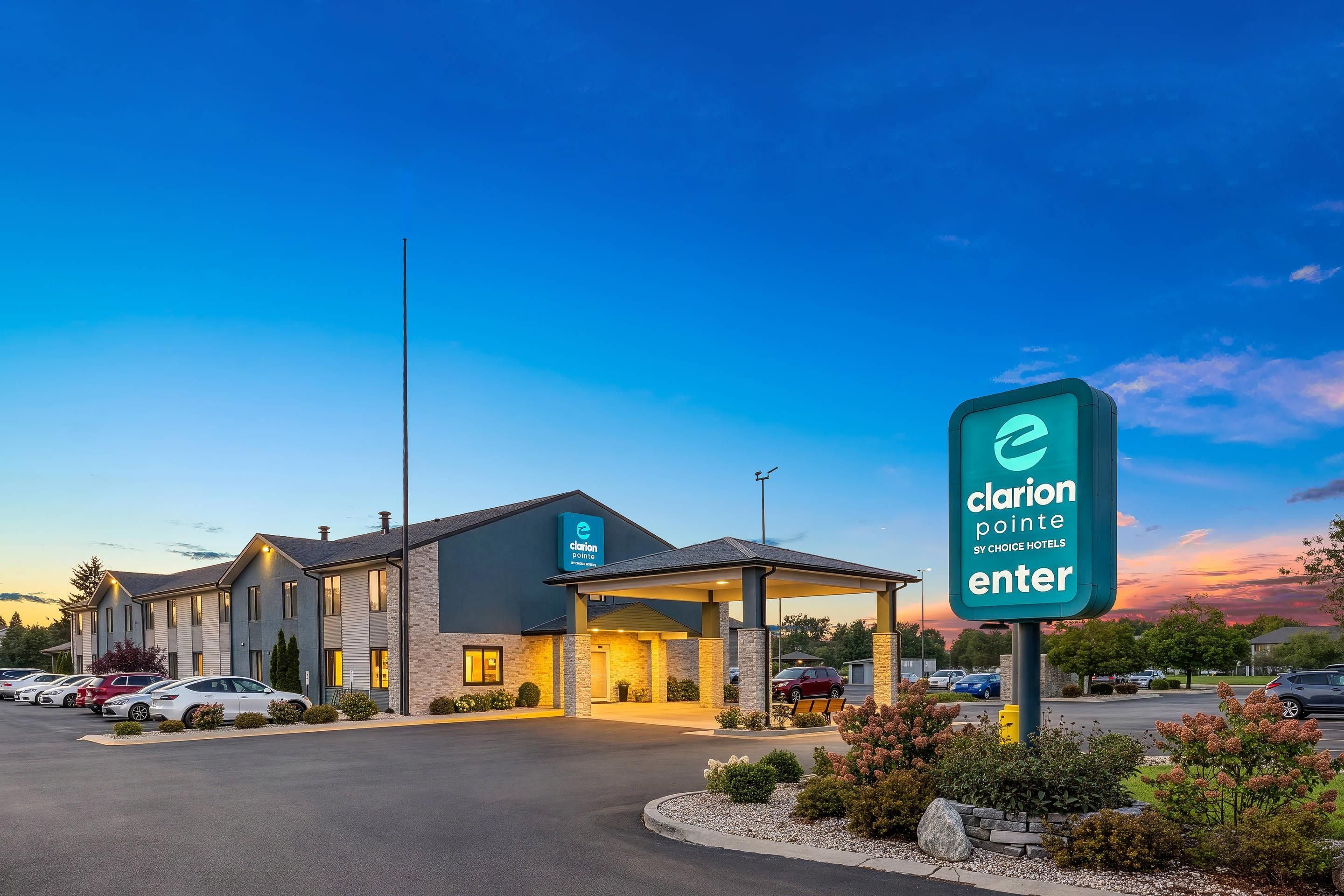 A hotel entrance with a sign indicating 'Clarion Pointe SY Choice Hotels'.