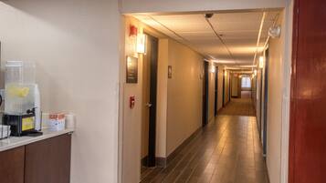 Corredor de hotel com uma máquina de café e um alarme de incêndio na parede.